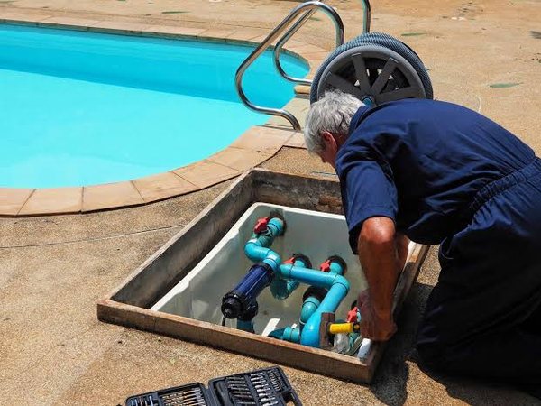 Técnico instalando tuberías y válvulas de una piscina